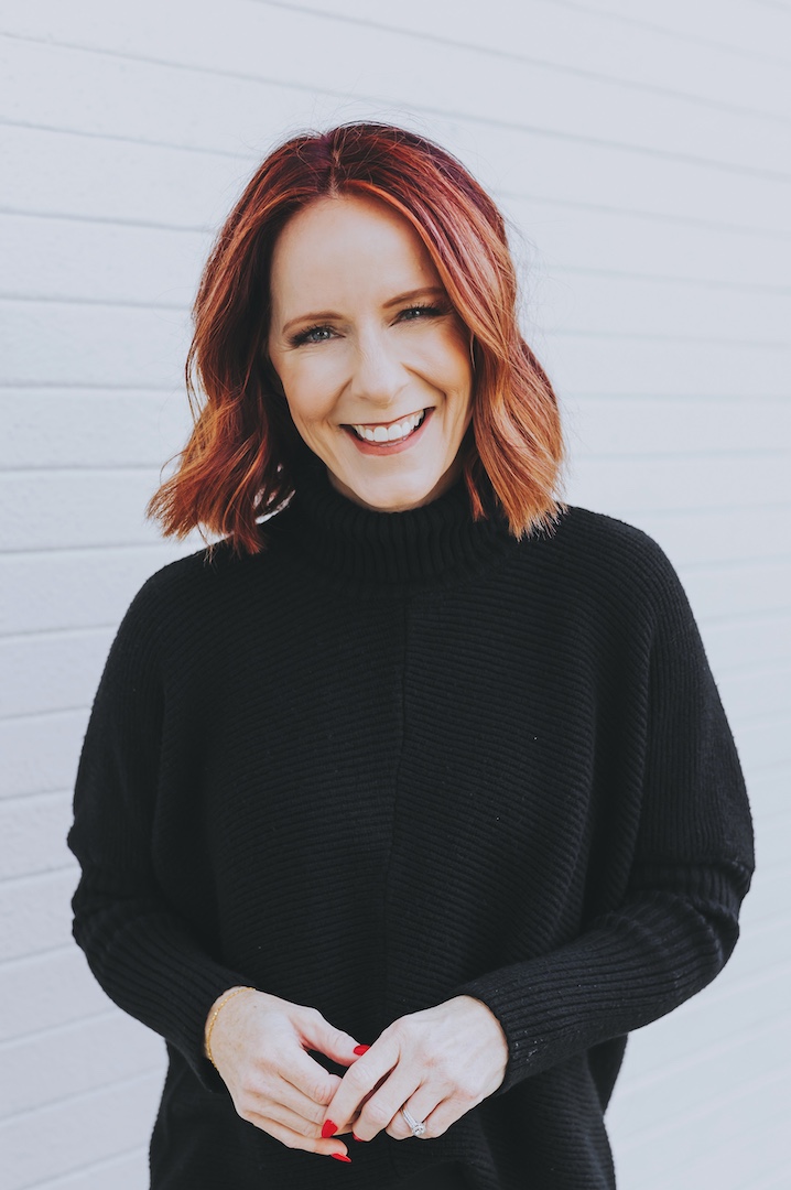 Photo of Delaina Baker wearing a black turtleneck sweater smiling.